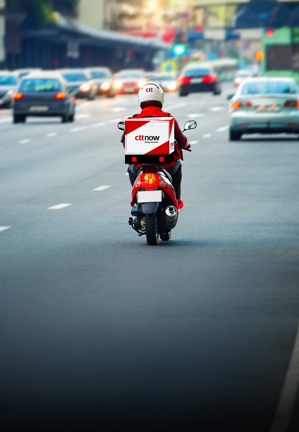 Estafeta numa mota a entregar uma encomenda enviada através do serviço CTT Now
