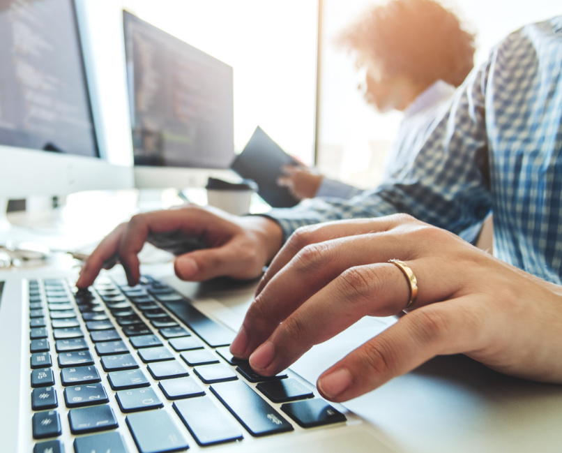 duas pessoas a trabalharem nos seus computadores.
