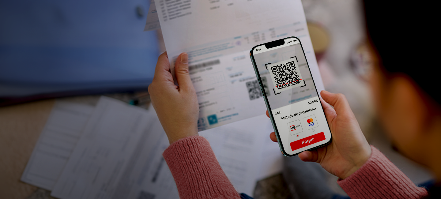 Senhora a pagar a sua fatura através da leitura de um Qr Code.